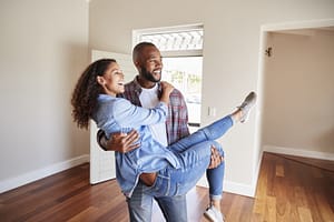 Man Carrying Woman Over Threshold Of Doorway In New Home on lifesource mortgage website