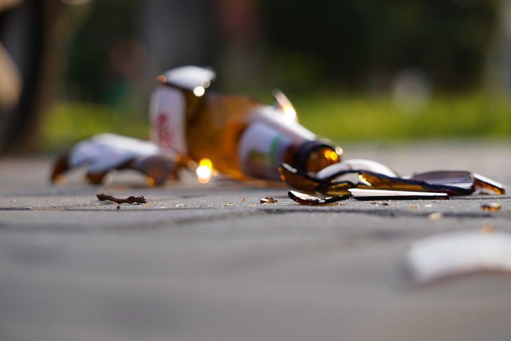 bottle of beer soda or drugs from dark glass is broken Shattered beer bottle on ground in sunset light Fragments of glass on asphalt Texture background wallpaper | Richard P. Davies, Esq.