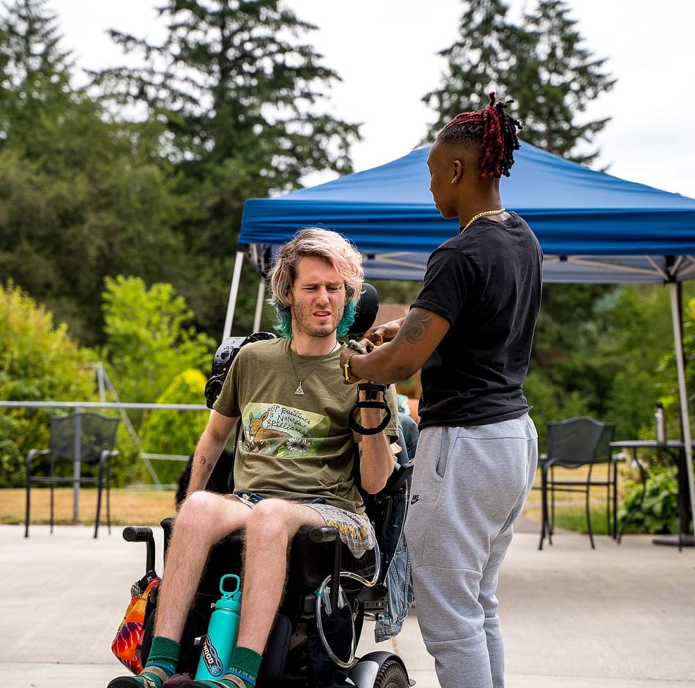 Person assisting a disabled individual at an inclusive recreation event