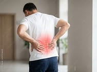 Man Back Pain AS_2107235691_Preview | Walker Road Chiropractic Man standing with hands on lower back, red glow highlighting pain in the lumbar area