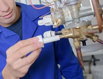 technician fixing a combination boiler in Reno, NV wearing a blue shirt