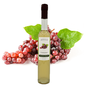 Champagne grapes behind a bottle of balsamic vinegar