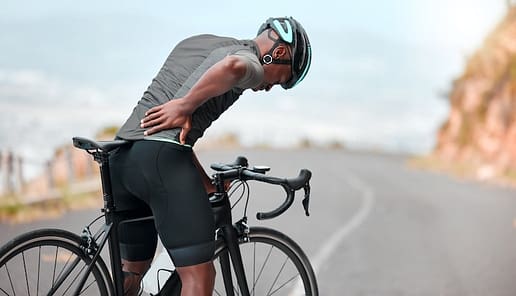 Fitness sports injury and back pain by man cyclist feel uncomfortable while cycling along mountain route Training pain and injured athletic guy suffering from herniated disc | Walker Road Chiropractic Fitness, sports injury and back pain by man cyclist feel uncomfortable while cycling along mountain route. Training, pain and injured athletic guy suffering from herniated disc